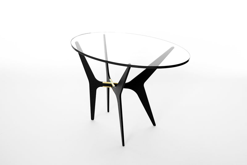 The luxurious Dean Oval Side Table is inspired by mid-century modern design but with a minimalist metallic structure softened by the rounded edges of the sleek glass top.