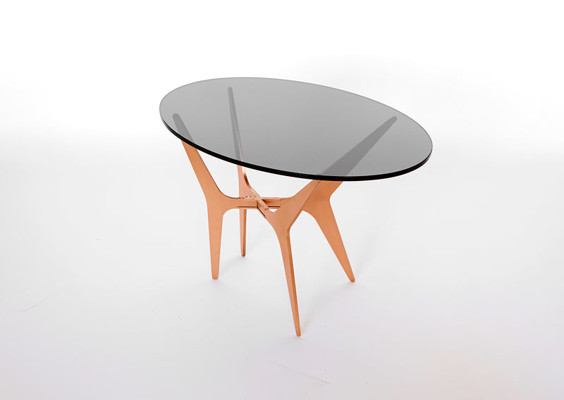 The luxurious Dean Oval Side Table is inspired by mid-century modern design but with a minimalist metallic structure softened by the rounded edges of the sleek glass top.