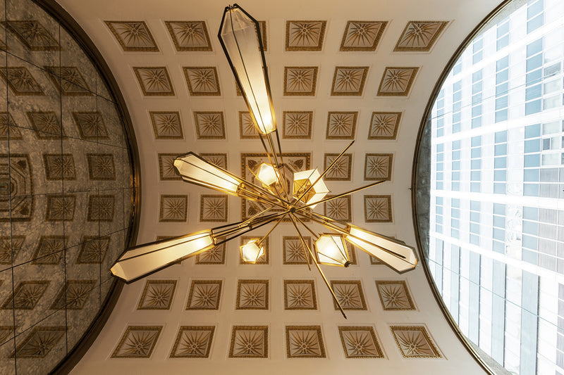 The Harlow Chandelier is directly inspired by the world of jewelry with its metallic frame encasing a translucent glass adding a touch of glamor to any residential or hospitality space.