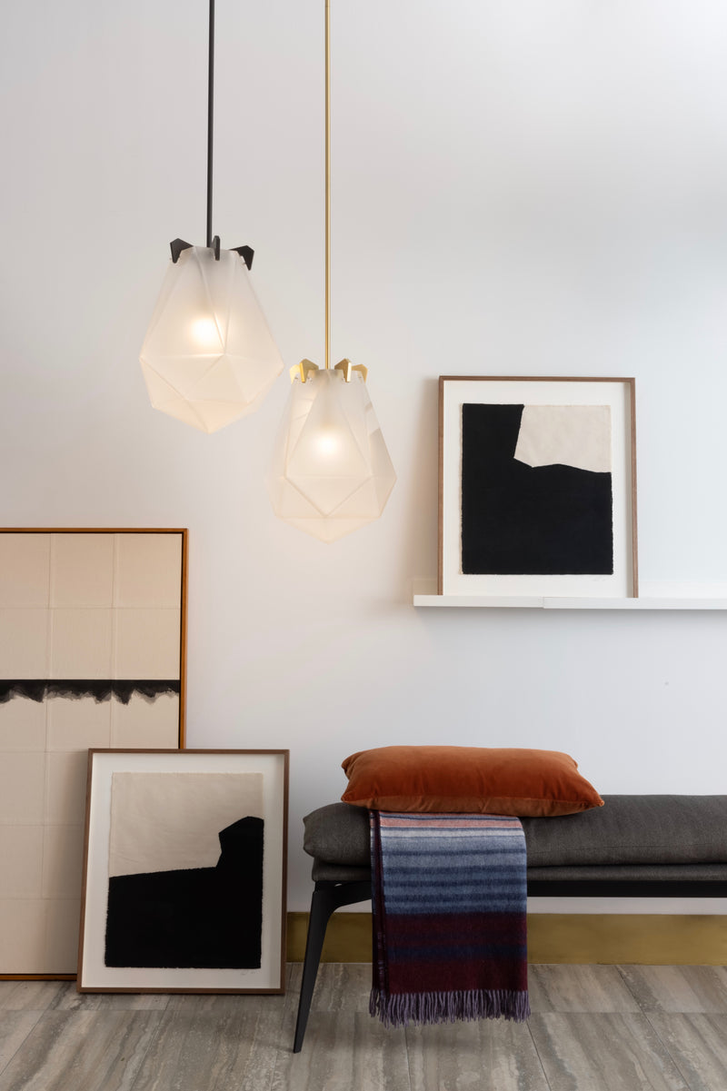 A powerful warm light diffused through double-blown glass, the Briolette Small Pendant showcases striking prismatic contours held by the brand’s signature metallic prongs.