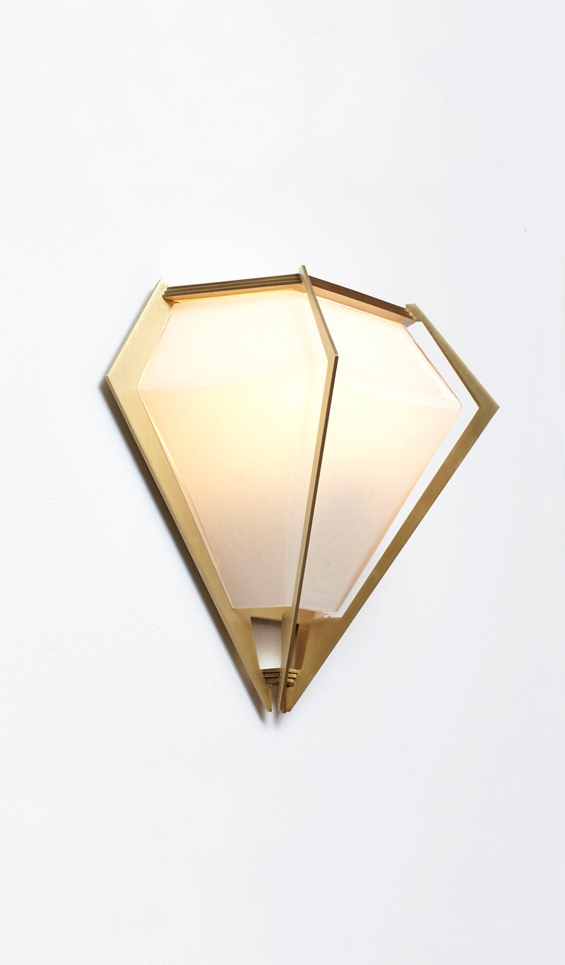 The Harlow wall sconce is an elegant sculptural handmade light fixture inspired by jewelry design featuring a mold-blown glass gem in a chic metallic setting. Created by contemporary designer, Gabriel Scott, the Harlow wall sconce is luxury wall lighting for both bedroom and living room.